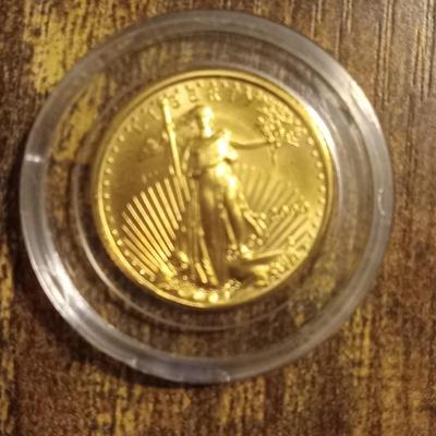 Sale Photo Thumbnail #2: In Display box. Says First American Eagle. $5.00 Gold Coin of the Millennium. 91% pure gold.