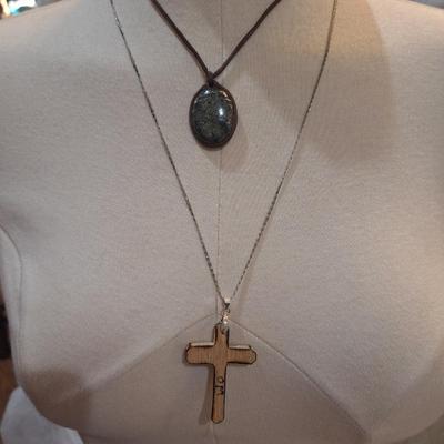 Sale Photo Thumbnail #176: Lot of 2 necklaces, silver chain with wooden cross pendant and leather strap with rock or similar pendant.