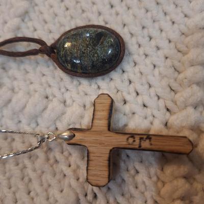 Sale Photo Thumbnail #178: Lot of 2 necklaces, silver chain with wooden cross pendant and leather strap with rock or similar pendant.