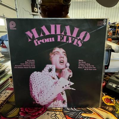 Sale Photo Thumbnail #149: "Mahalo from Elvis," a compilation album by American singer and musician Elvis Presley. 
Album details include:
Release: The album was released posthumously in September 1978 by Pickwick Records in arrangement with RCA Records.
Content: Side one features 