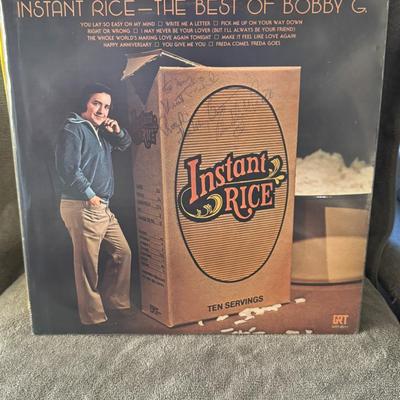 Sale Photo Thumbnail #387: "Instant Rice - The Best Of Bobby G." by American country music singer-songwriter Bobby G. Rice. 
Here is more information about the album and artist:
Artist: Bobby G. Rice, a country music singer-songwriter known for hits in the 1970s and 80s.
Album Titl