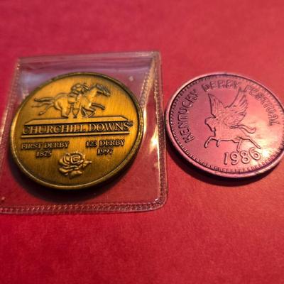 Sale Photo Thumbnail #46: This auction lot is for a grouping of Kentucky Derby Coins. This a pair of Kentucky Derby Coins.  The bronze colored coin is commemorating the 1997 Running of the Roses and come with its own plastic envelope.  The purple coin is a 1986 beer token.  It fee