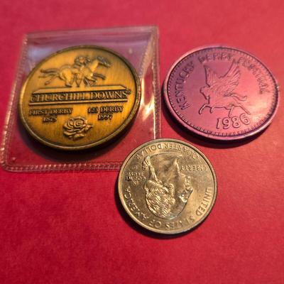 Sale Photo Thumbnail #48: This auction lot is for a grouping of Kentucky Derby Coins. This a pair of Kentucky Derby Coins.  The bronze colored coin is commemorating the 1997 Running of the Roses and come with its own plastic envelope.  The purple coin is a 1986 beer token.  It fee