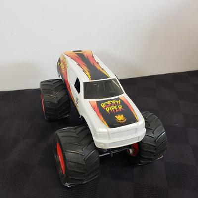 LOT 147: Vintage WWF Road Champs Cars, Roddy Piper Monster Truck, WCW Diamond Dallas Page Keychain & John Cena Action Figure