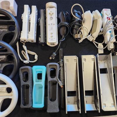 Sale Photo Thumbnail #63: Nintendo Wii Huge Lot of Racing Wheels Controllers Stands & much more.
Will receive all items pictured as is. A couple controllers do not have backs.