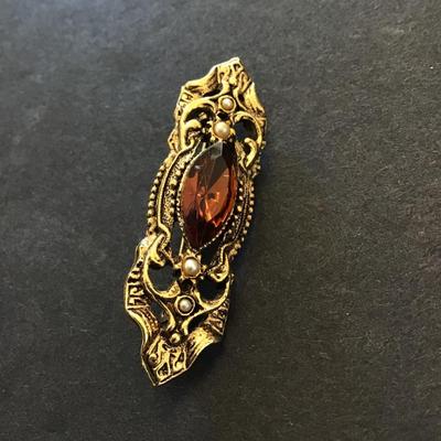 Pretty gold tone brooch with glass stone
