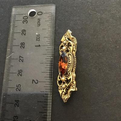 Pretty gold tone brooch with glass stone