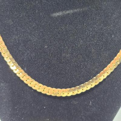 Thick gold toned necklace chain with several gold toned earrings and a bangle bracelet