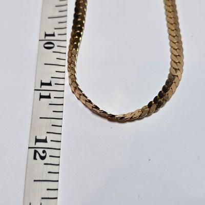 Thick gold toned necklace chain with several gold toned earrings and a bangle bracelet