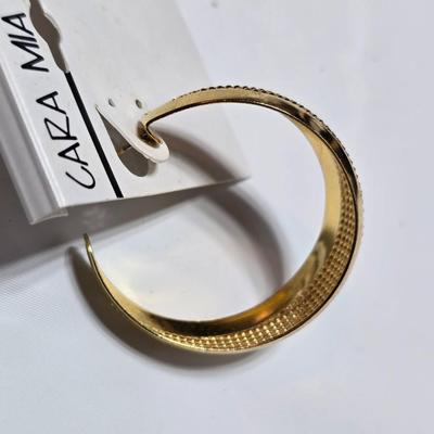 Thick gold toned necklace chain with several gold toned earrings and a bangle bracelet