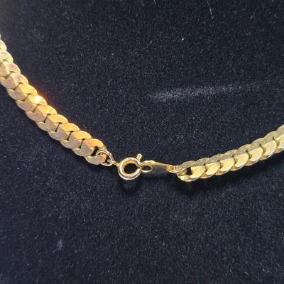 Thick gold toned necklace chain with several gold toned earrings and a bangle bracelet