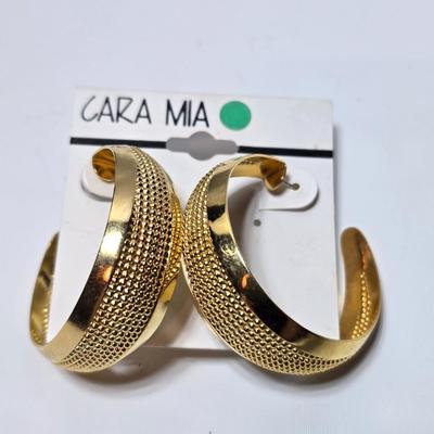 Thick gold toned necklace chain with several gold toned earrings and a bangle bracelet
