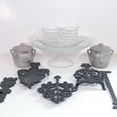 LOT 185: Cast Iron Trivets, Pewter Bean Pots, Pressed Glass Cakestand & More