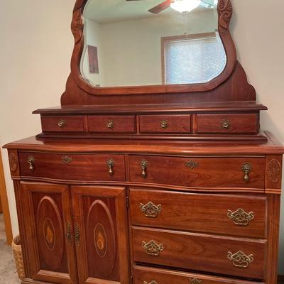 Tall wood dresser with mirror and shell design on doors