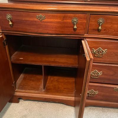 Tall wood dresser with mirror and shell design on doors