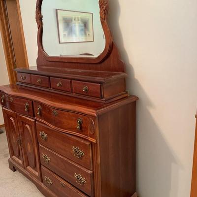 Tall wood dresser with mirror and shell design on doors