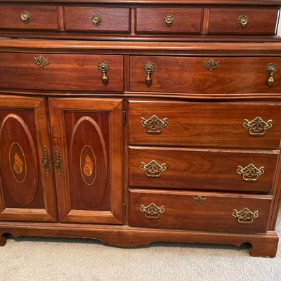 Tall wood dresser with mirror and shell design on doors