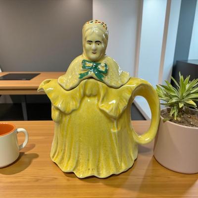 Sale Photo Thumbnail #296: Vintage "Little Old Lady"/"Grandmother" Teapot Made In England.  Slight Color Variation Between the lid and the base.  Paint missing on the green bow.
Approximately 8.5" Tall