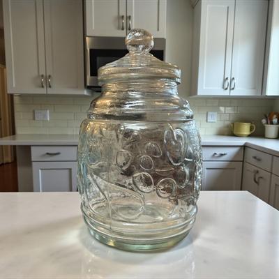 Sale Photo Thumbnail #342: Clear Glass Cookie Jar or Canister with an embosses Fruit Design and a Lift Off Lid
Approximately 12.5" tall