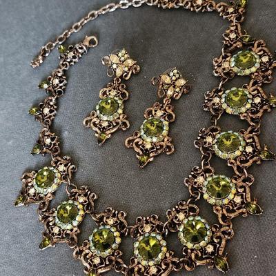 Sale Photo Thumbnail #274: This is a visually stunning set of jewelry.  Olive green rhinestones are set in an antique
bronze tone setting of ornate metalwork.  This is a statement necklace.
The matching pierced earrings complete the vision.
Enjoy!!!