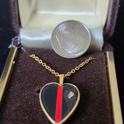 Sale Photo Thumbnail #295: Black and red stripe pendant set in gold tone setting, with genine diamond accent.