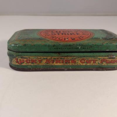 Sale Photo Thumbnail #173: Antique Lucky Strike Tobacco Tin- Circa 1920's- Approx 4 1/4" x 2 3/4" x 1 1/4" Tall.  Please see all pictures for condition.