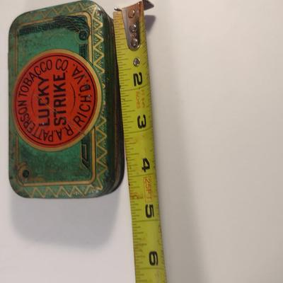 Sale Photo Thumbnail #176: Antique Lucky Strike Tobacco Tin- Circa 1920's- Approx 4 1/4" x 2 3/4" x 1 1/4" Tall.  Please see all pictures for condition.