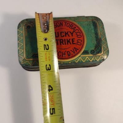Sale Photo Thumbnail #177: Antique Lucky Strike Tobacco Tin- Circa 1920's- Approx 4 1/4" x 2 3/4" x 1 1/4" Tall.  Please see all pictures for condition.