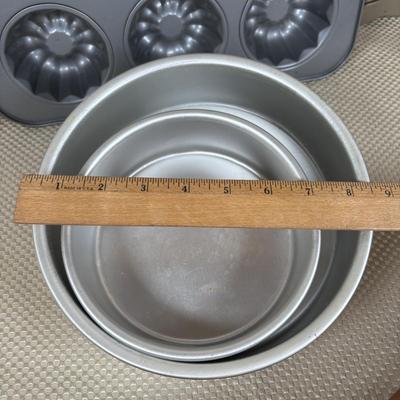 LOT 95: Bakers Delight: Pamper Chef Cookie Press, Longaberger Yellow Pie Plate, Spring Form Pan, Autum Cake-lite Pan, Wilton Round Pans,...