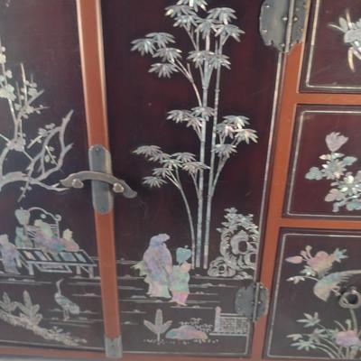 Sale Photo Thumbnail #561: Antique Chinese Wooden Storage Box with Mother of Pearl Inlay- Approx 17 1/2" x  8 3/4" x 16" Tall.  Back is drilled for possible wall hanging.  One foot/leg needs repair- please see all pictures for condition.