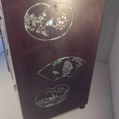 Sale Photo Thumbnail #572: Antique Chinese Wooden Storage Box with Mother of Pearl Inlay- Approx 17 1/2" x  8 3/4" x 16" Tall.  Back is drilled for possible wall hanging.  One foot/leg needs repair- please see all pictures for condition.