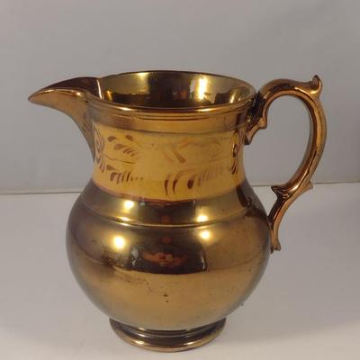 Sale Photo Thumbnail #604: Antique English Lusterware Pitcher- Copper Color with Cream Band- Approx 6" Tall.  Small chip on bottom of handle.