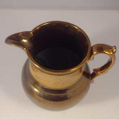 Sale Photo Thumbnail #605: Antique English Lusterware Pitcher- Copper Color with Cream Band- Approx 6" Tall.  Small chip on bottom of handle.