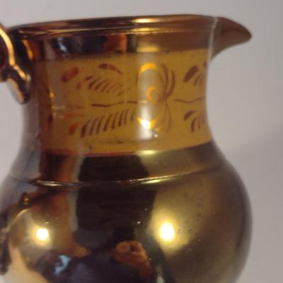Sale Photo Thumbnail #607: Antique English Lusterware Pitcher- Copper Color with Cream Band- Approx 6" Tall.  Small chip on bottom of handle.