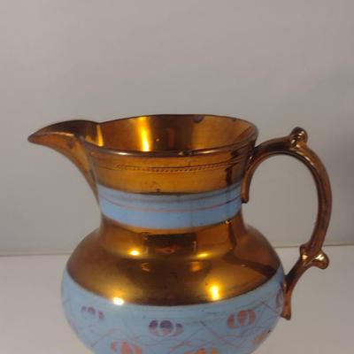 Sale Photo Thumbnail #618: Antique English Lusterware Pitcher- Copper Color with Blue Bands- Approx 6 1/2" Tall.  Item has chipping on rim and spout- please see all pictures.
