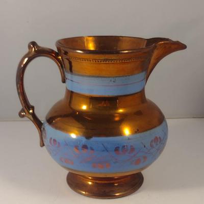 Sale Photo Thumbnail #620: Antique English Lusterware Pitcher- Copper Color with Blue Bands- Approx 6 1/2" Tall.  Item has chipping on rim and spout- please see all pictures.