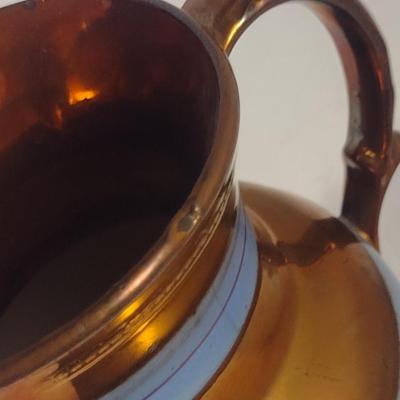 Sale Photo Thumbnail #625: Antique English Lusterware Pitcher- Copper Color with Blue Bands- Approx 6 1/2" Tall.  Item has chipping on rim and spout- please see all pictures.