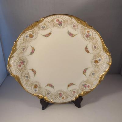 Sale Photo Thumbnail #708: Limoges France Porcelain Gilt Serving Plate- Approx 13 1/4" in Diameter.  Plate stand not included.