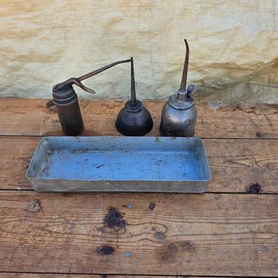 Three vintage metal oil cans with spouts and a metal tray