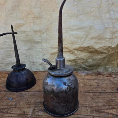 Three vintage metal oil cans with spouts and a metal tray