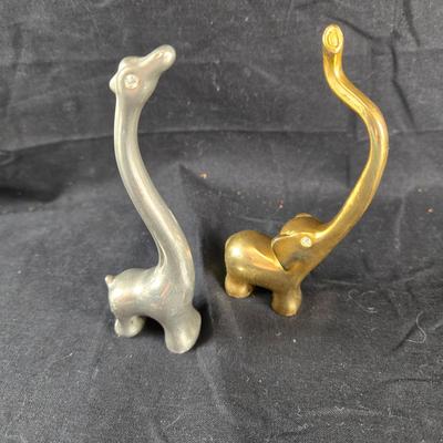 Sale Photo Thumbnail #130: This auction lot is for a pair of Animal Ring Holders. This is a fun and handsome pair of Ring Holder Animals.  The Giraffe is stainless and the Elephant is brass.  They both have faux diamond eyes for bling.  Smart and stylish way of keeping your rings s