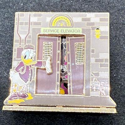 Sale Photo Thumbnail #14: Pin in very good condition. This Disney trading pin features Donald Duck, Mickey Mouse, and Minnie Mouse in a scene inspired by The Twilight Zone Tower of Terror attraction. 
The pin is a diorama-style pin, with Donald dressed as a bellhop leading Mickey 