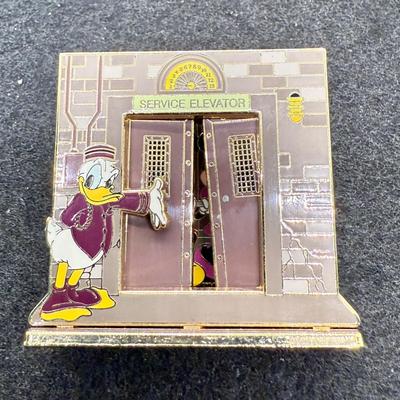 Sale Photo Thumbnail #13: Pin in very good condition. This Disney trading pin features Donald Duck, Mickey Mouse, and Minnie Mouse in a scene inspired by The Twilight Zone Tower of Terror attraction. 
The pin is a diorama-style pin, with Donald dressed as a bellhop leading Mickey 