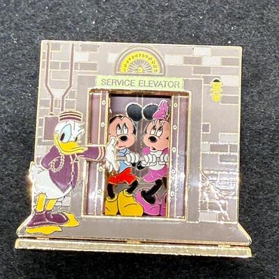 Sale Photo Thumbnail #16: Pin in very good condition. This Disney trading pin features Donald Duck, Mickey Mouse, and Minnie Mouse in a scene inspired by The Twilight Zone Tower of Terror attraction. 
The pin is a diorama-style pin, with Donald dressed as a bellhop leading Mickey 