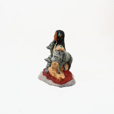 Native American- sculpture featuring a woman sitting with three wolves.