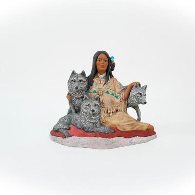 Native American- sculpture featuring a woman sitting with three wolves.