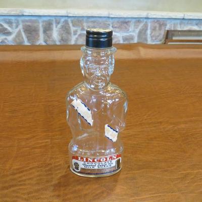Sale Photo Thumbnail #75: Vintage 1950's Abraham Lincoln glass bank bottle, with chocolate syrup label, approx 8.5" tall