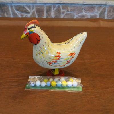 Sale Photo Thumbnail #82: 1950's Wyandotte tin litho egg-laying hen with marbles included. Measure7.5"H x 8"W