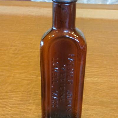 Sale Photo Thumbnail #96: Father John's medicine embossed amber glass bottle from Lowell, Massachusetts. c. 1855-1875, measures 10" H in excellent condition