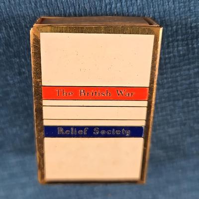 Sale Photo Thumbnail #173: This auction lot is for a WWII British War Relief Match Society Holder. It is brass and enamel with the cardboard match drawer inside.  The one side is engraved - "There will always be an England".  It is in good used condition and contains no matches.